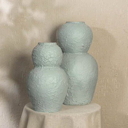 Light blue textured decorative vase styled in a warm modern room adding artistic sculptural decor to living rooms hallways and contemporary interiors.