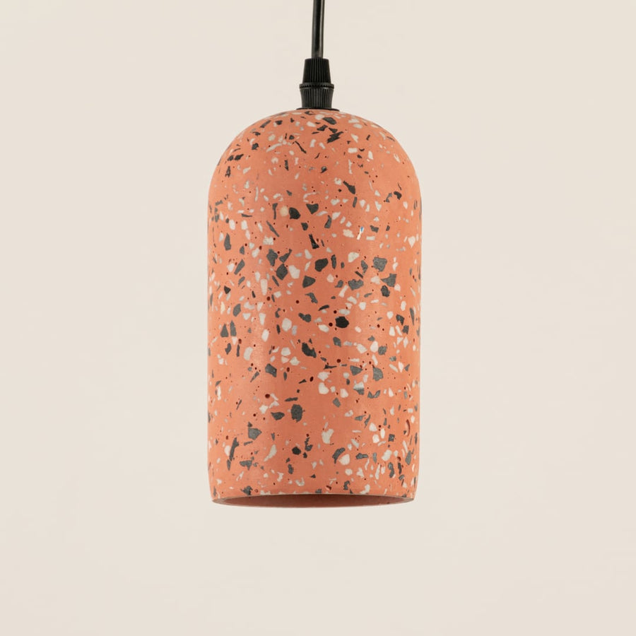 Terracotta terrazzo pendant light with smooth matte finish and speckled pattern in a modern cylindrical dome shape.