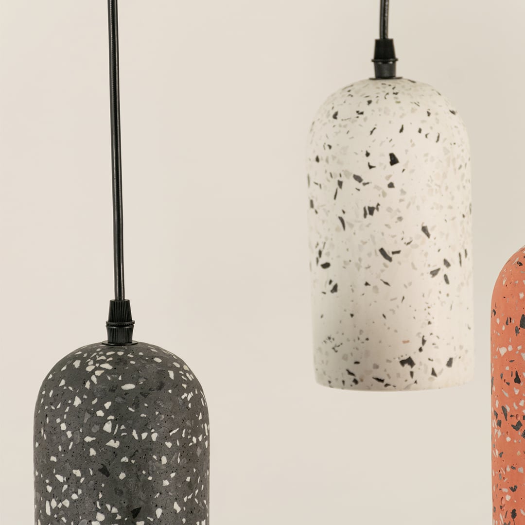 Terracotta terrazzo pendant light with smooth matte finish and speckled pattern in a modern cylindrical dome shape.