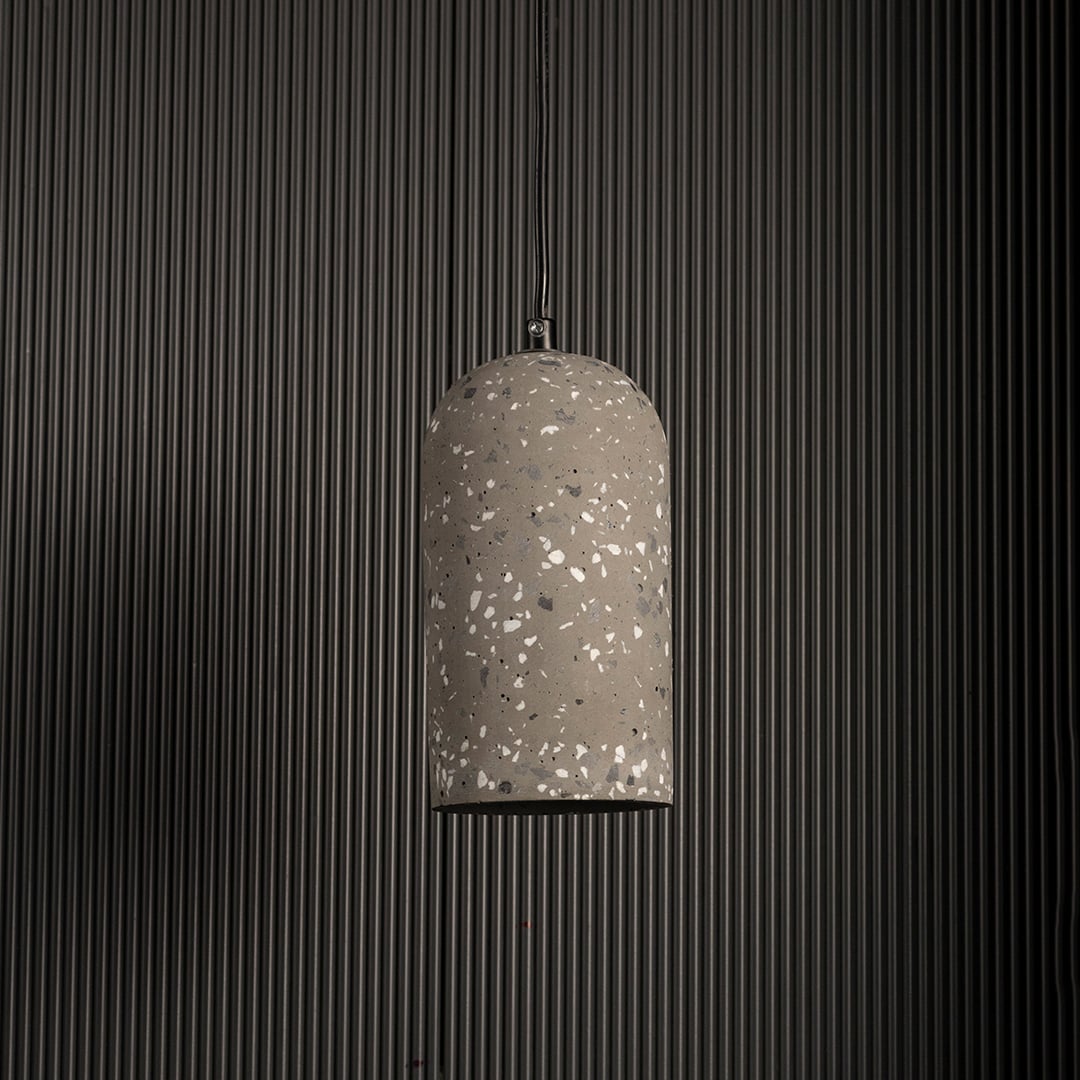 Warm terrazzo pendant light turned off highlighting its grey textured surface against a dark background for a modern industrial look.