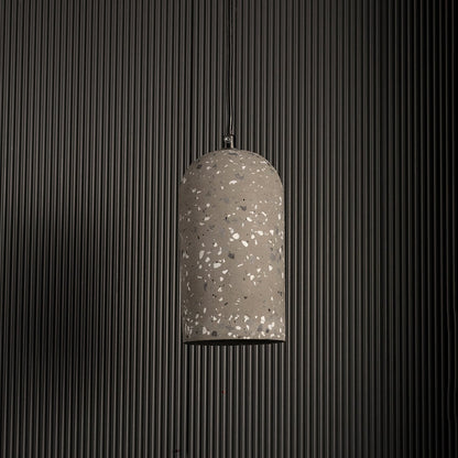 Warm terrazzo pendant light turned off highlighting its grey textured surface against a dark background for a modern industrial look.