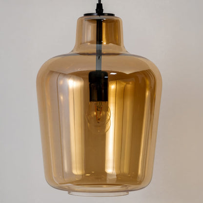 Closeup view of the amber pendant light highlighting the smooth glass finish warm glow and visible inner bulb detail