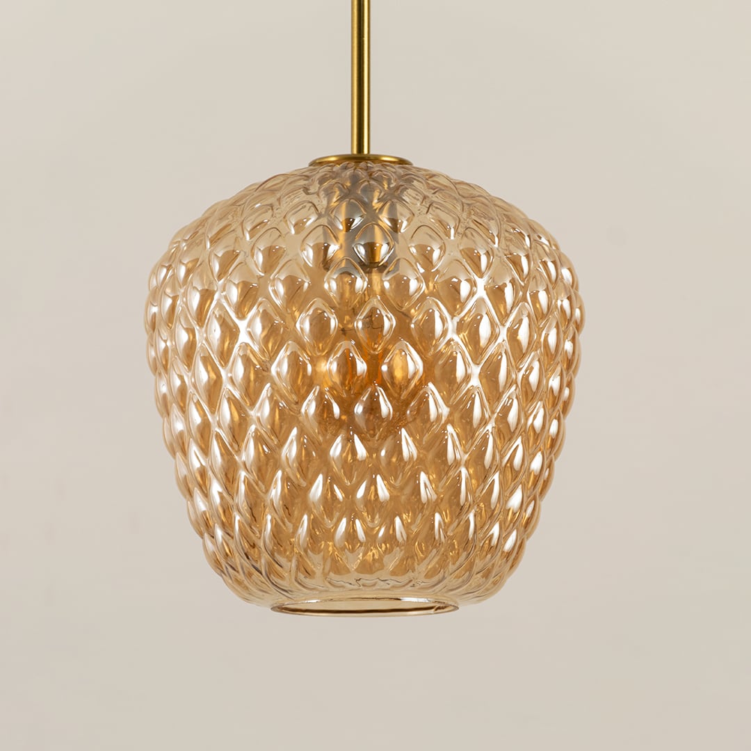 Closeup capturing the textured amber glass and warm glowing bulb showing intricate detailing and refined craftsmanship for decorative lighting.