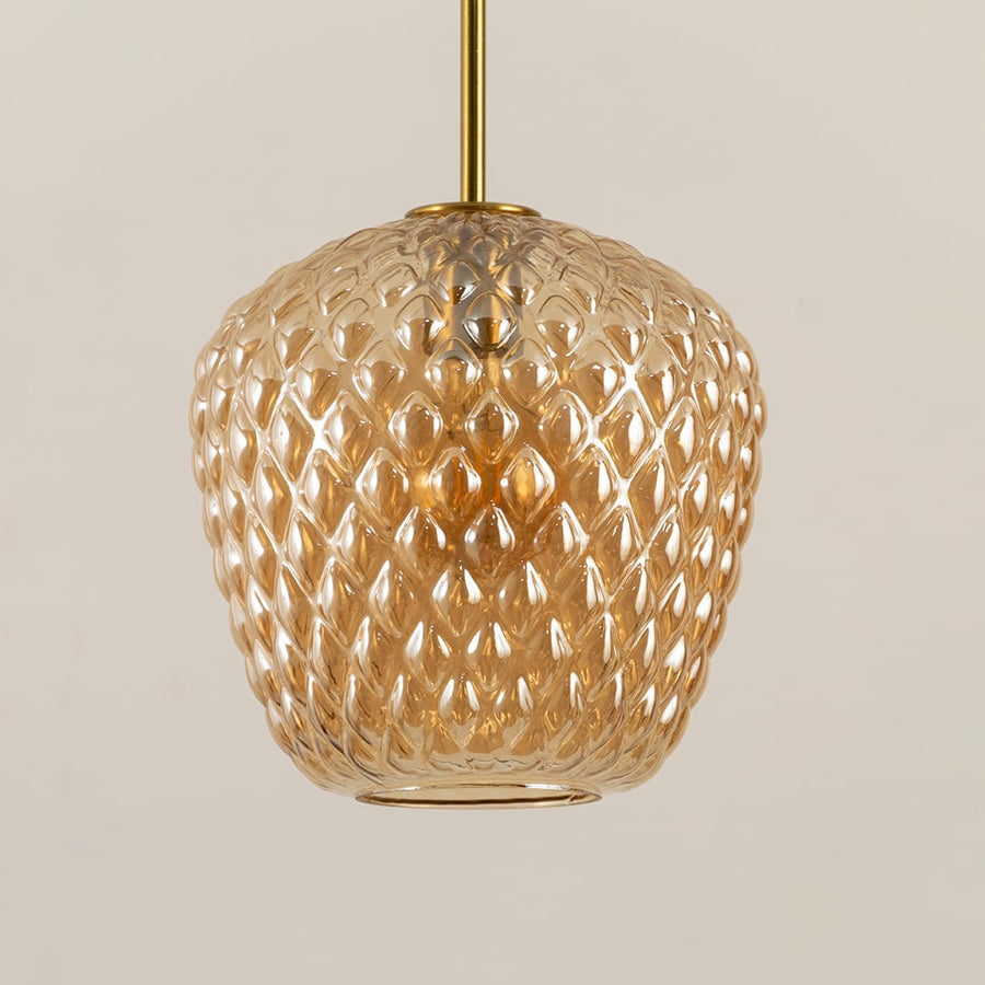 Closeup capturing the textured amber glass and warm glowing bulb showing intricate detailing and refined craftsmanship for decorative lighting.