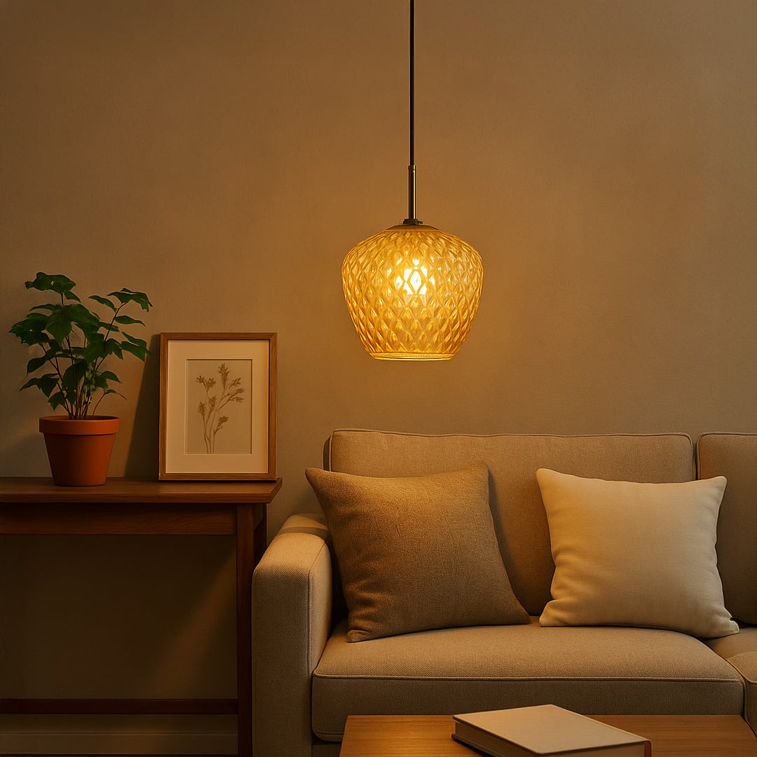 Textured amber glass pendant light with warm bulb hanging above a beige sofa creating a soft cozy glow in a modern living room interior.