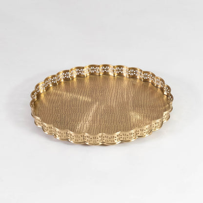 Gold finish brass plate with scalloped edge and textured base placed on white background for elegant serveware.