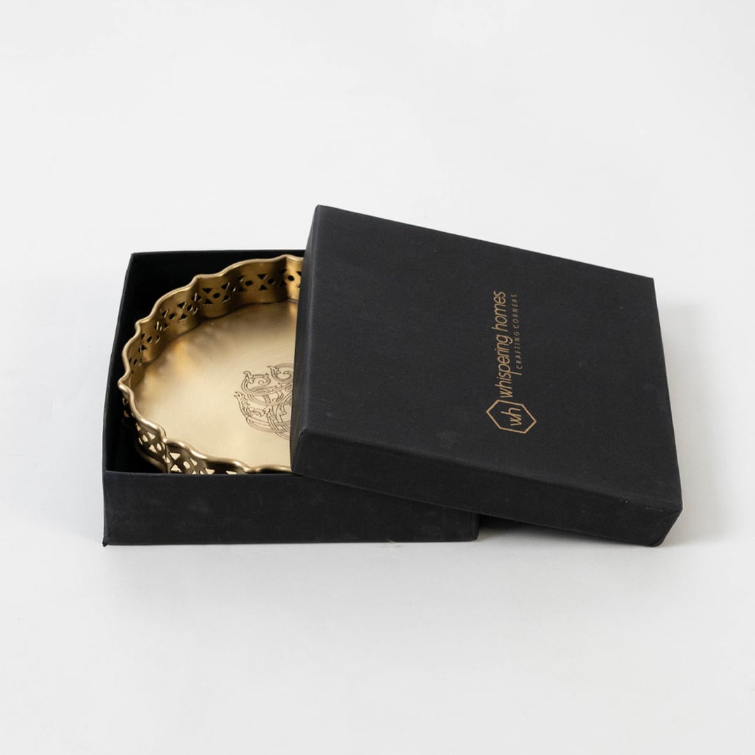 Gold brass plate with floral pattern packed in black premium box with logo branding shown on clean white surface.
