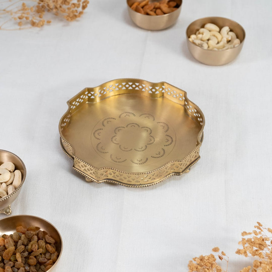 Gold finish brass plate with floral detailing and scalloped edges displayed on a clean white background surface.