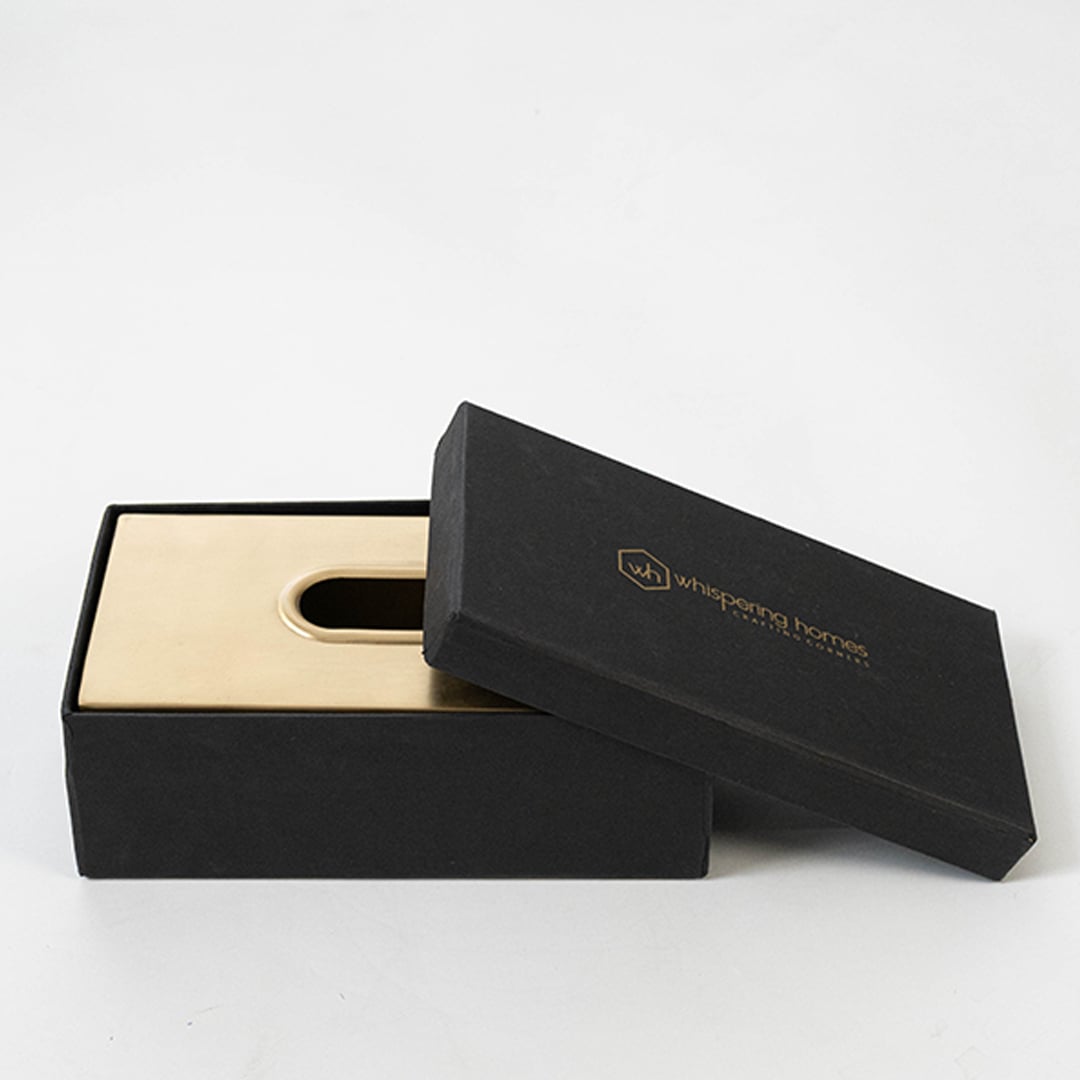 Top view of golden metal tissue box showing centered oval slot and smooth matte finish with neat base outline.