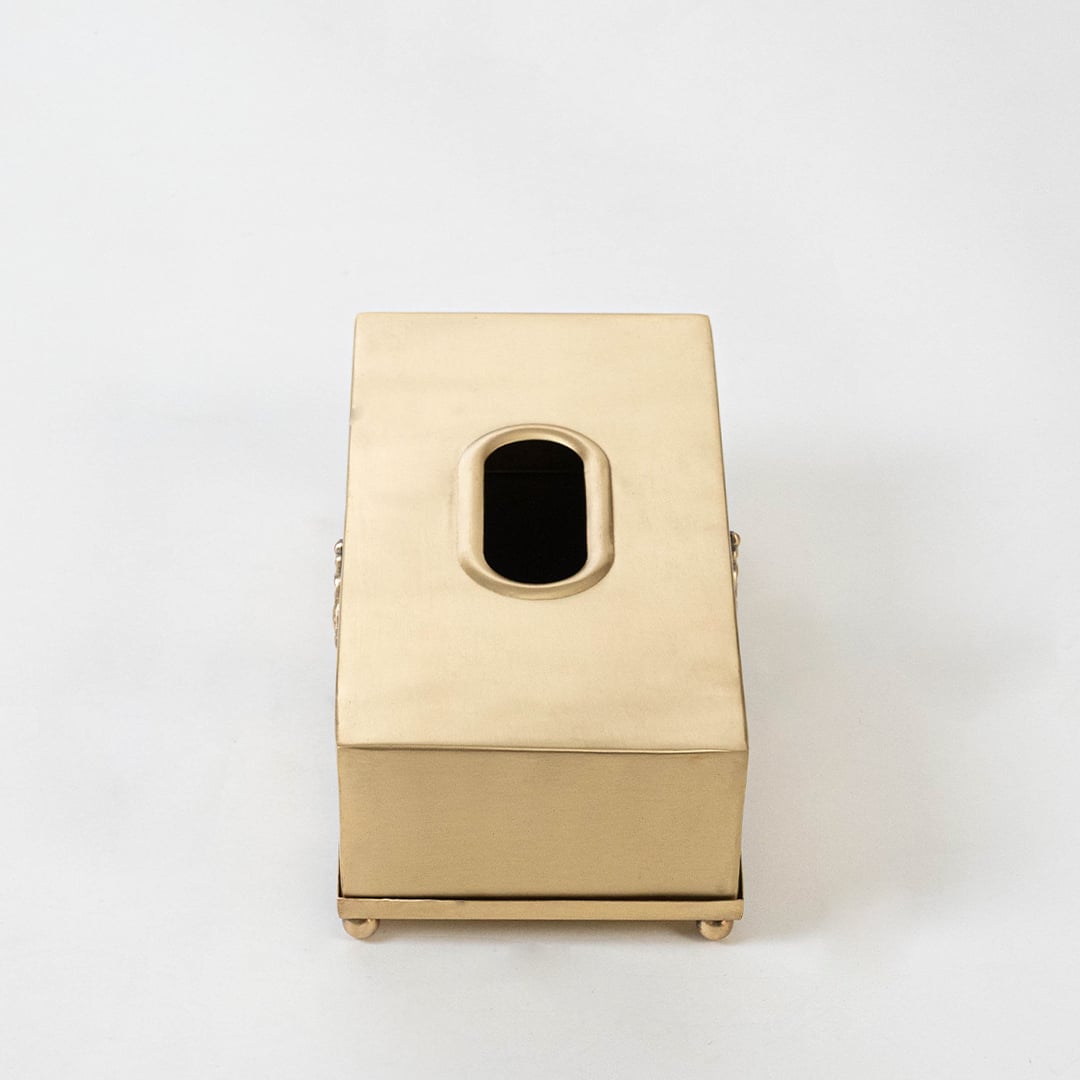 Gold metal tissue holder with 25 cm length 13 cm width and 9 cm height shown with engraved motif and foot base.