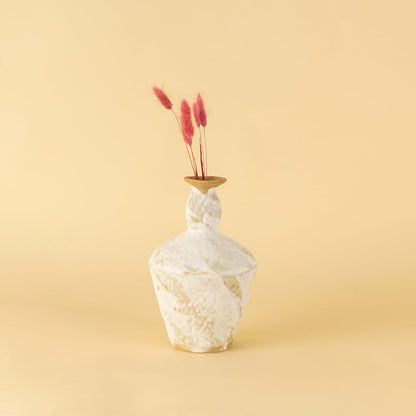 Tall rustic white and brown ceramic vase with textured finish styled on table adding earthy charm to home interior.