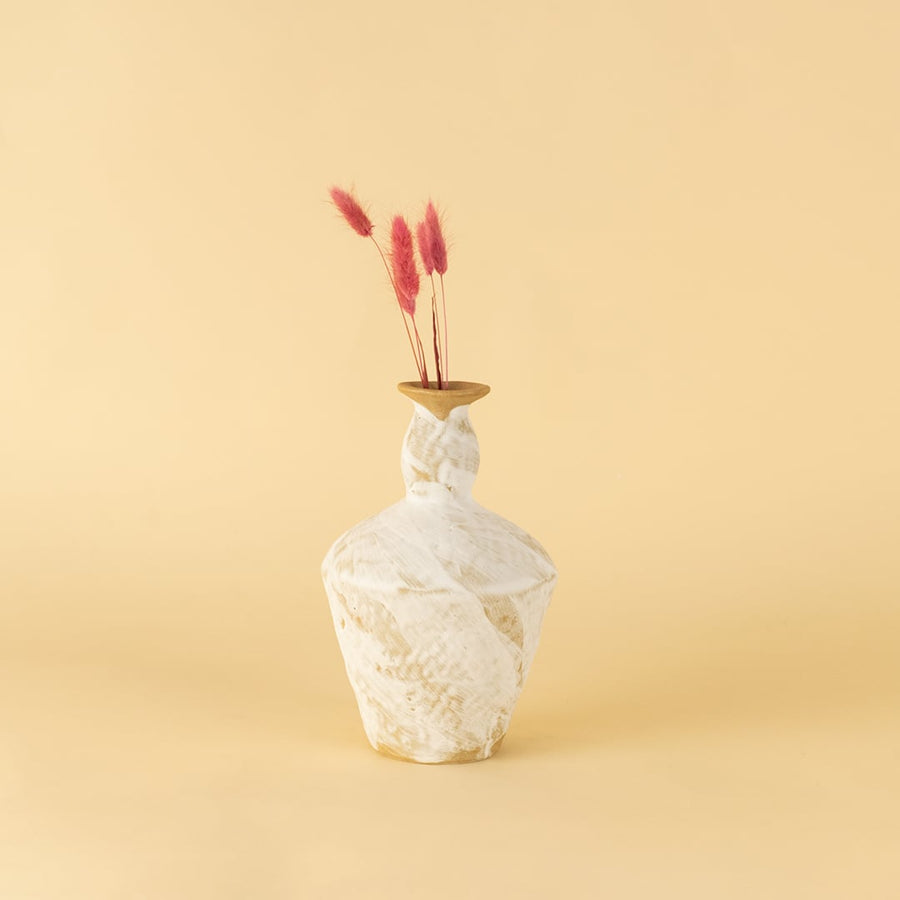 Tall rustic white and brown ceramic vase with textured finish styled on table adding earthy charm to home interior.