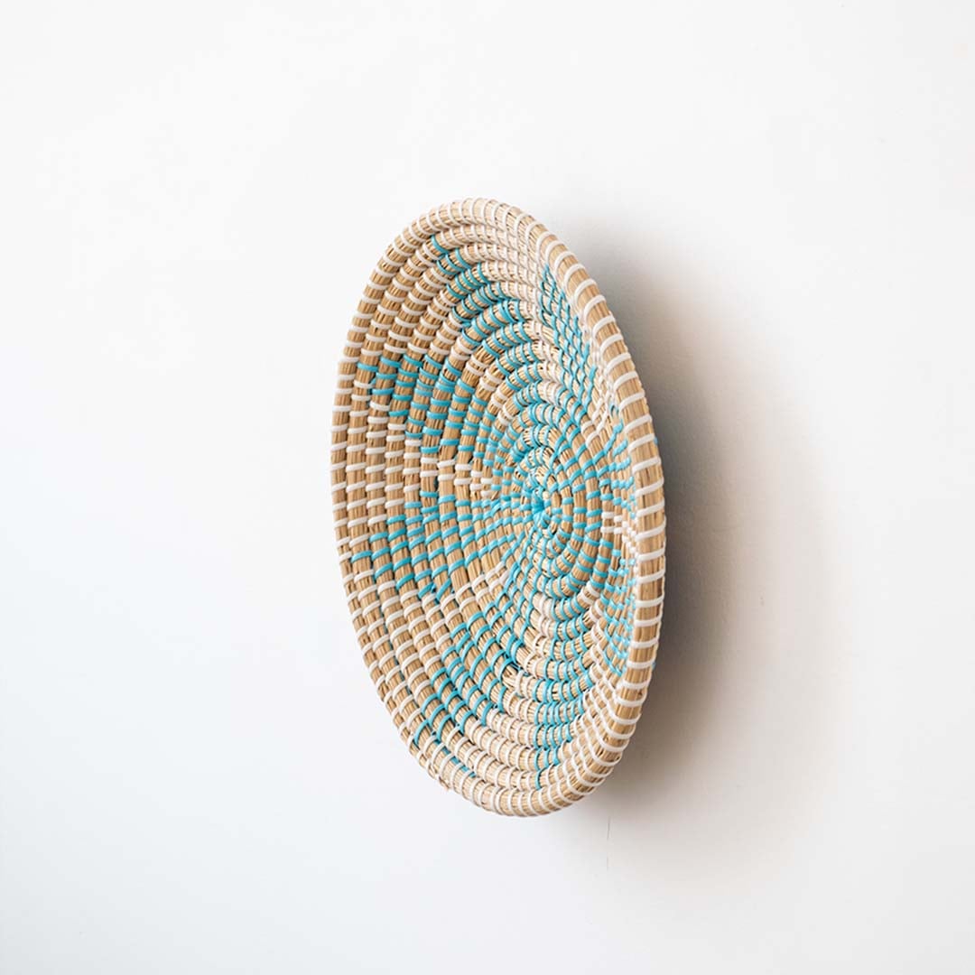 Side view of natural fiber basket with turquoise woven details ideal for rustic and bohemian interiors.