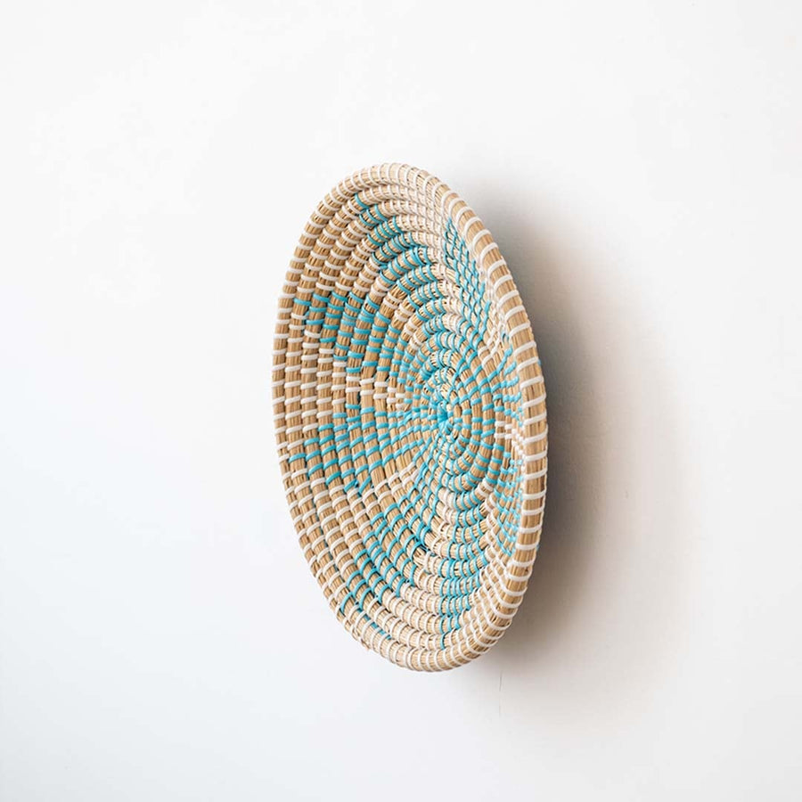 Side view of natural fiber basket with turquoise woven details ideal for rustic and bohemian interiors.