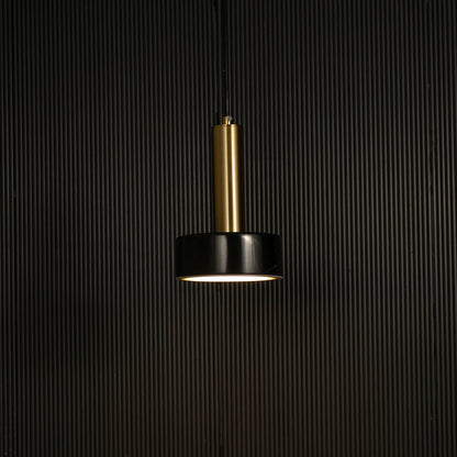 Black marble and metal round base pendant light hanging against dark textured wall with light off for luxury interior décor.