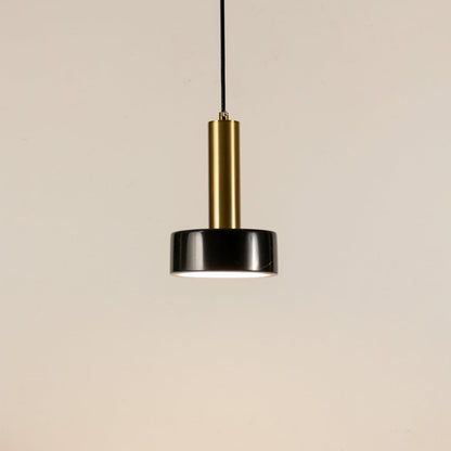 Black marble and metal round base pendant light hanging against plain background with light off for modern luxury décor.