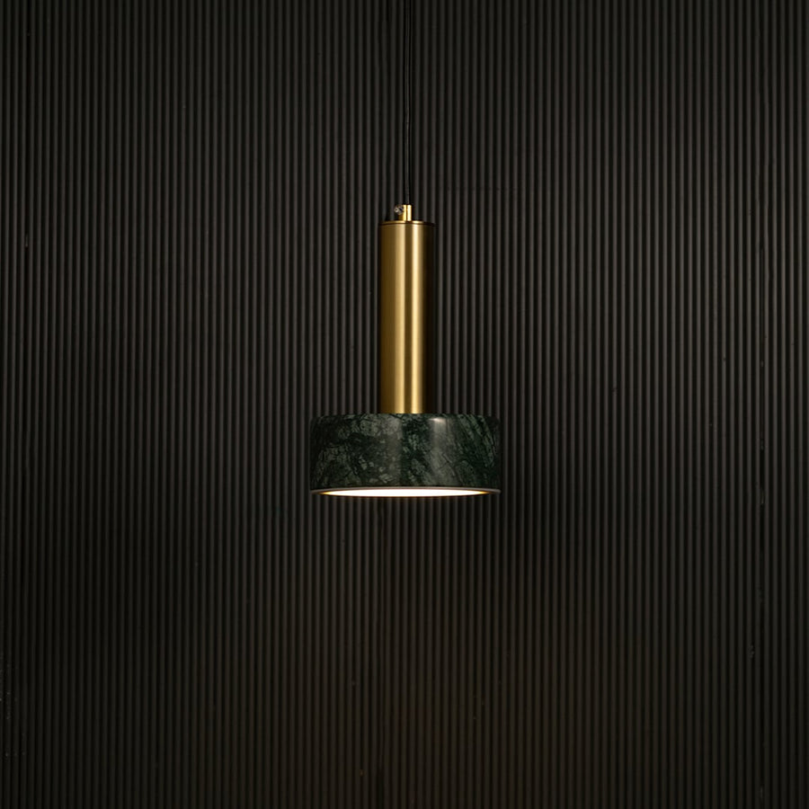 Green marble and metal round base pendant light hanging against dark textured wall with light off for premium modern décor.