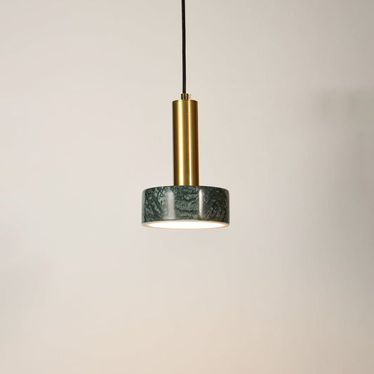 Green marble and metal round base pendant light hanging against plain background with light off for stylish modern décor.