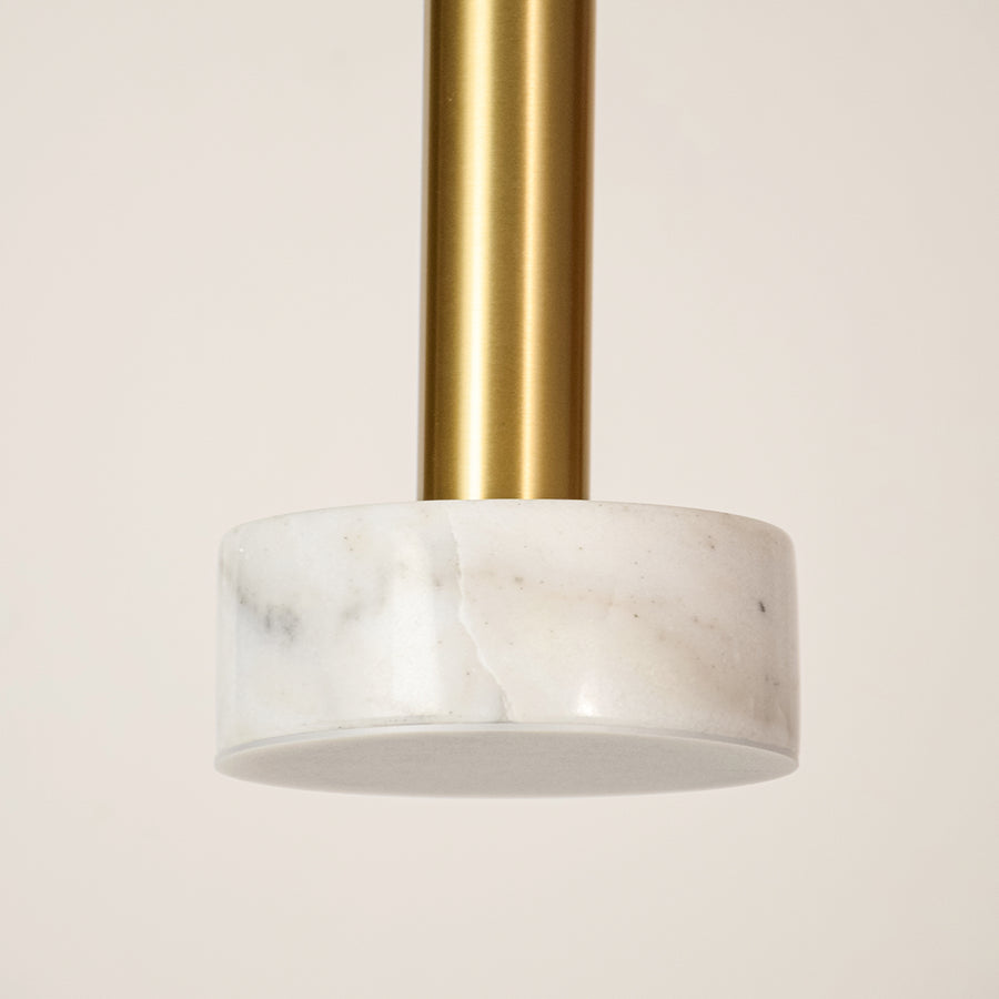 White marble and gold metal pendant light illuminated to showcase luxury ceiling lighting with elegant modern styling.