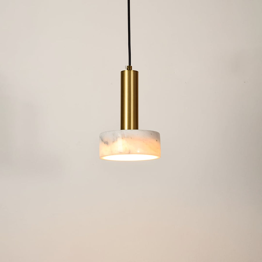 Gold metal pendant light with frosted glass diffuser illuminated to showcase modern ceiling lighting and warm glow.
