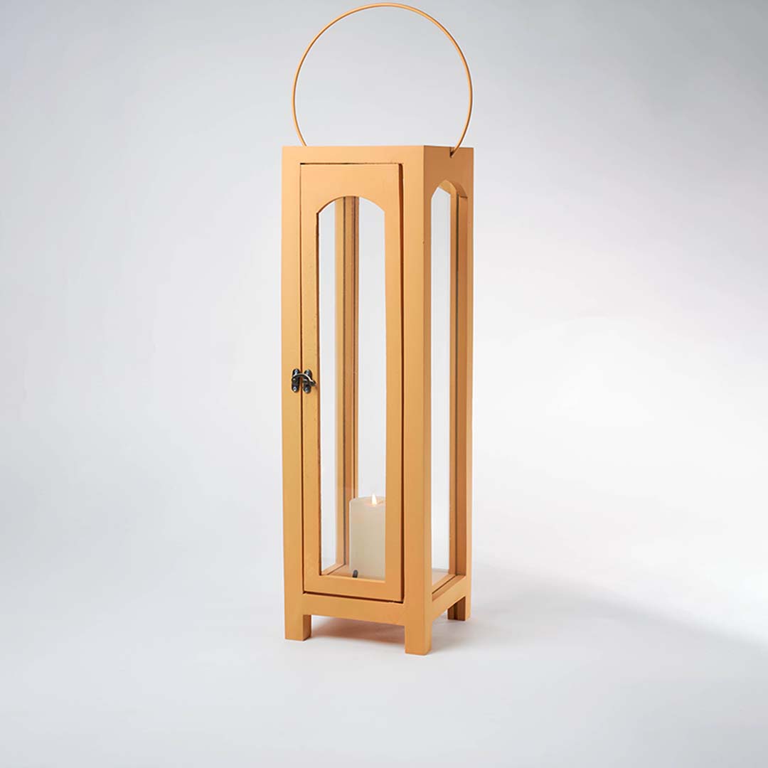 Glowing wooden garden lantern with a flickering candle inside on a white background creating a dramatic warm lighting contrast effect.