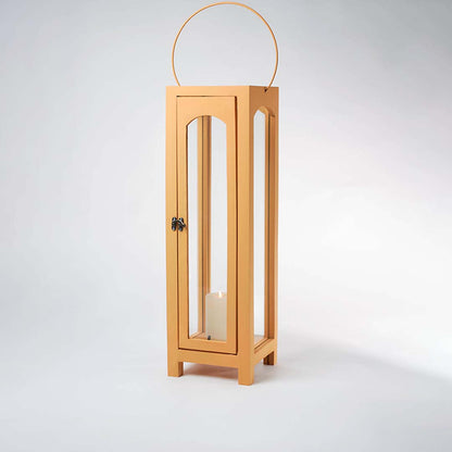 Glowing wooden garden lantern with a flickering candle inside on a white background creating a dramatic warm lighting contrast effect.