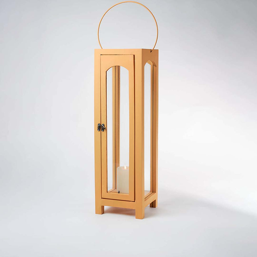 Glowing wooden garden lantern with a flickering candle inside on a white background creating a dramatic warm lighting contrast effect.