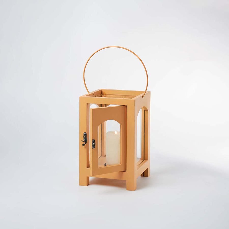 Wooden lantern with arch glass panels and metal handle for rustic tabletop decor styling use.