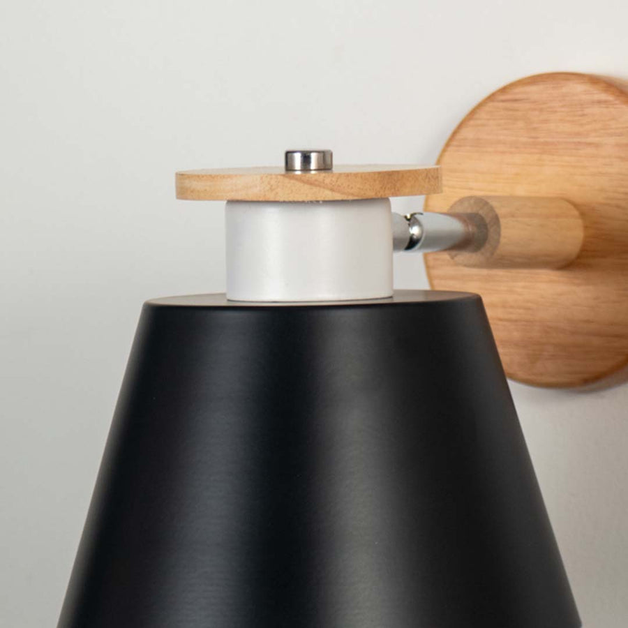 Closeup view of wooden wall sconce with black conical lampshade modern indoor wall light for bedroom living room and hallway table lamping.