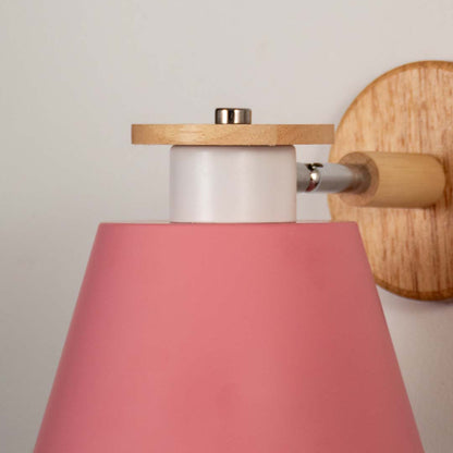 Closeup of pink metal and wooden wall light for modern bedroom and elegant decor styling spaces.

