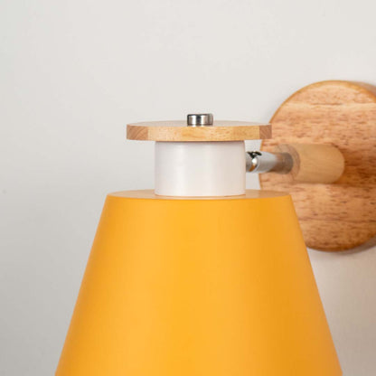 Closeup of mustard metal and wooden wall light for modern bedroom and elegant decor styling spaces.


