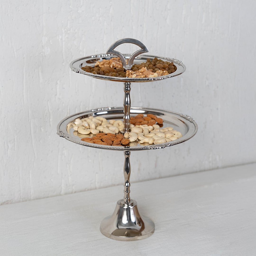 Empty two tier silver metal serving tray with decorative edges shown on a white background for product display.