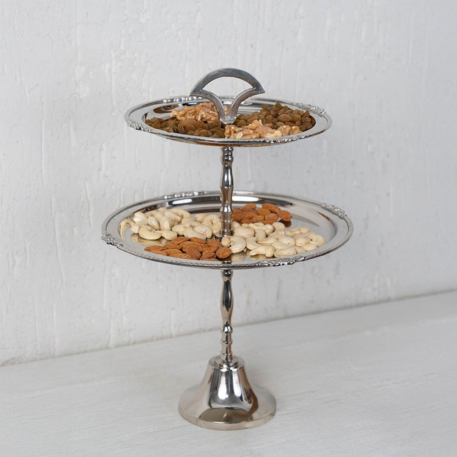 Empty two tier silver metal serving tray with decorative edges shown on a white background for product display.