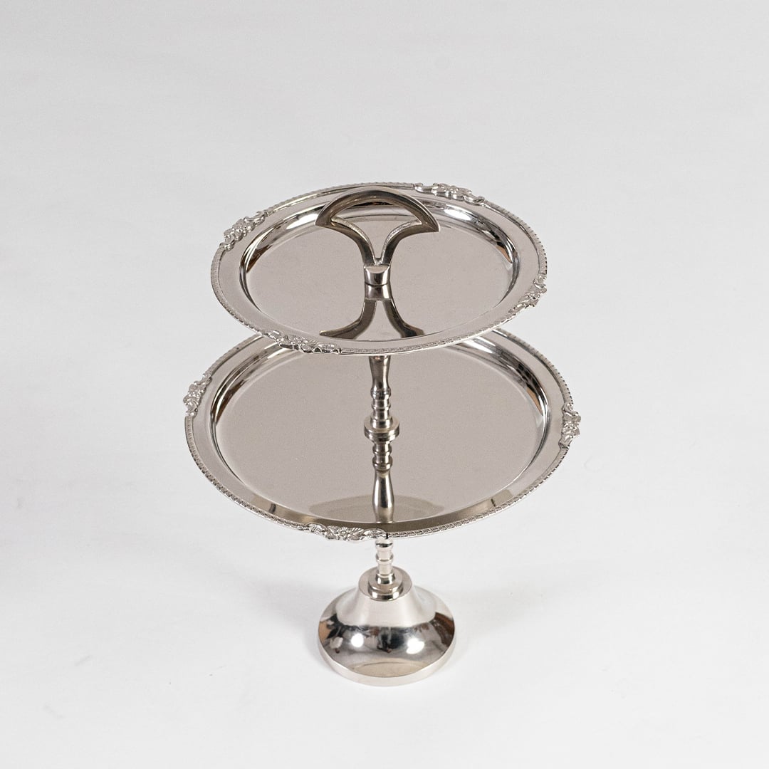 Disassembled silver metal two tier serving tray shown in a black branded box with lid partially open for packaging view.