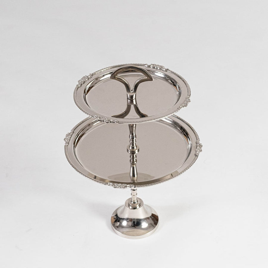 Disassembled silver metal two tier serving tray shown in a black branded box with lid partially open for packaging view.