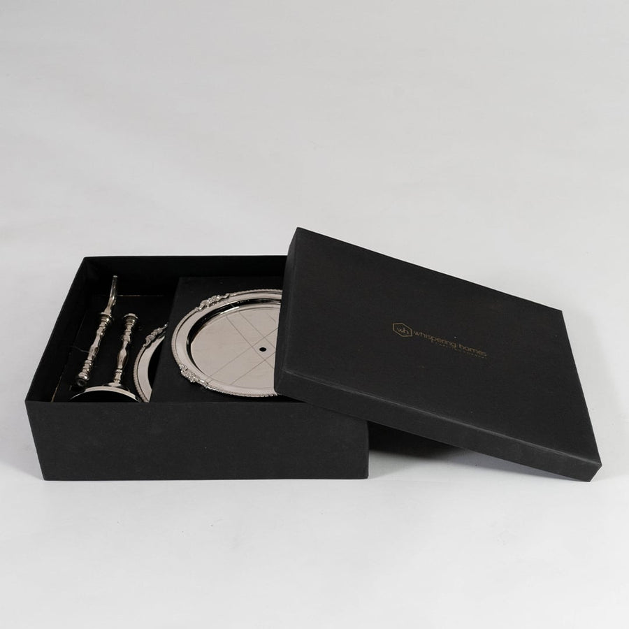 Two tier silver metal serving tray with ornate edges shown empty on a plain white background from a top view.