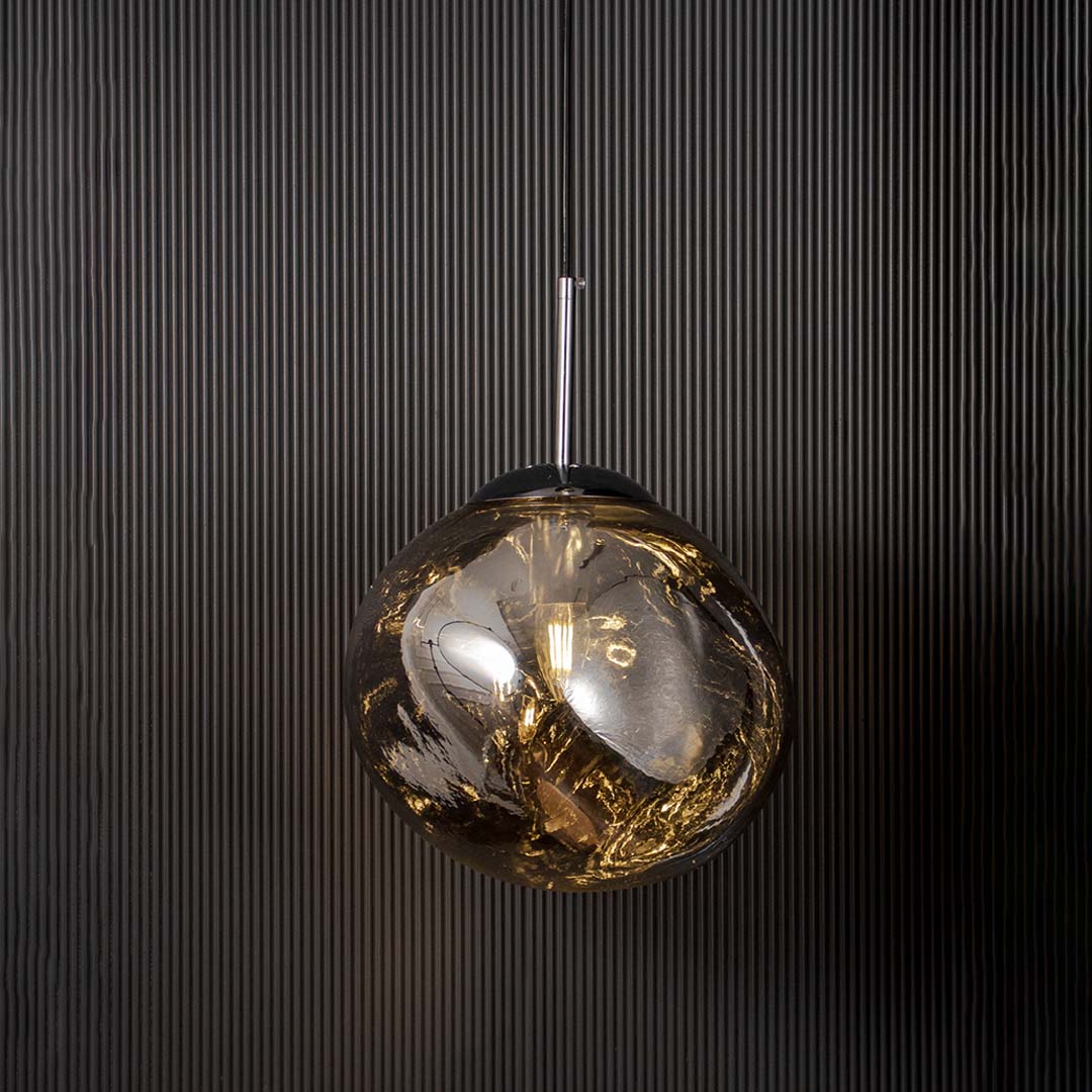Contemporary chrome pendant light glowing on dark backdrop highlighting its metallic reflective finish.