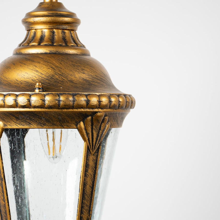 Antique brass metal hanging lantern light with textured glass and detailed frame for premium outdoor decor.
