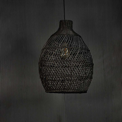 Contemporary black rattan pendant light against black background featuring handwoven texture and refined modern natural look.