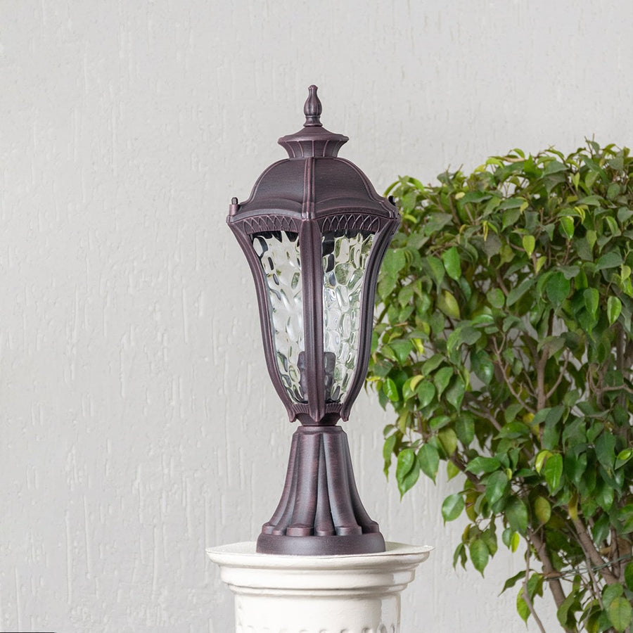 Antique brown pillar light with patterned clear glass displayed off on white background highlighting timeless classic style.
