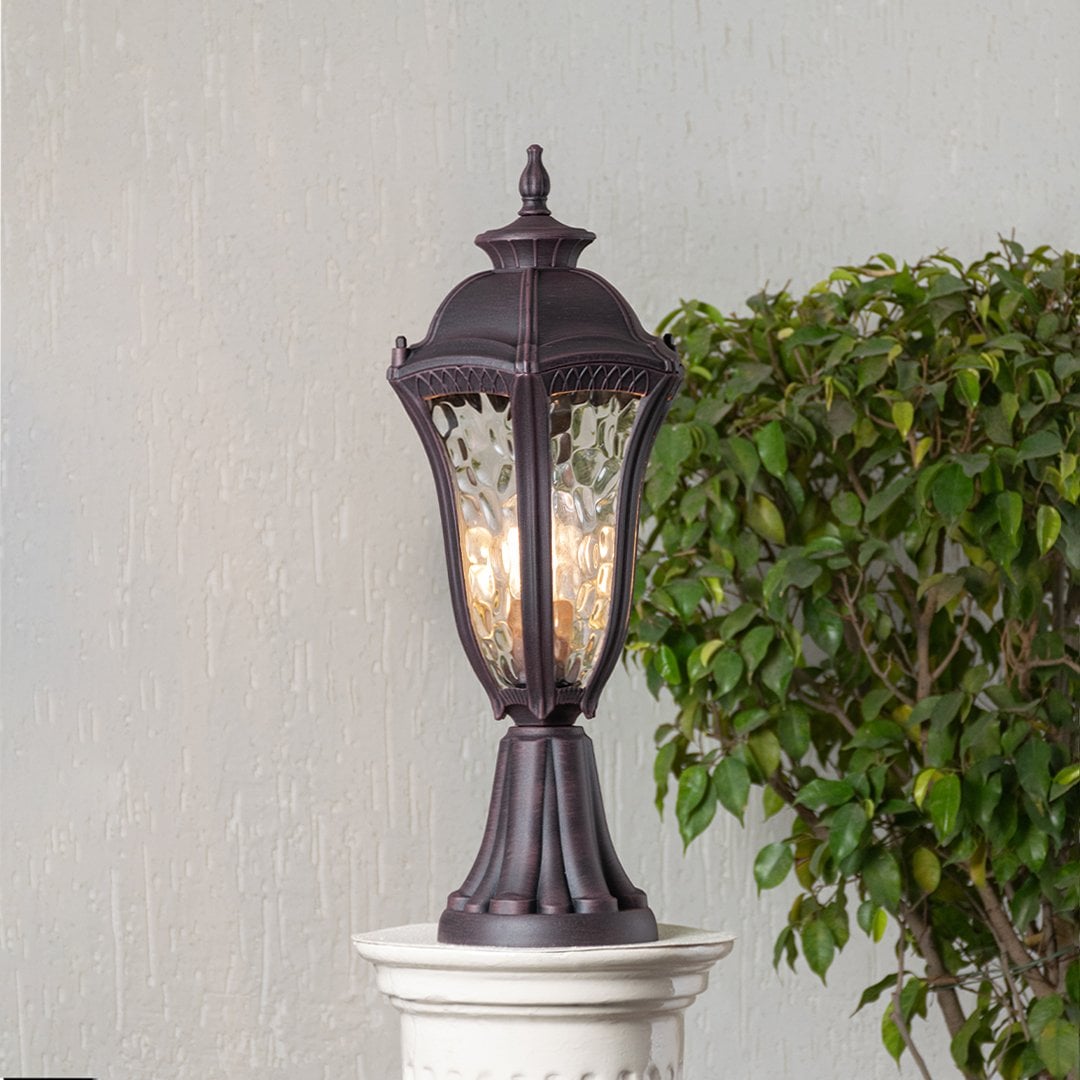 Antique brown pillar light with patterned clear glass displayed on white background for elegant outdoor or garden decor.