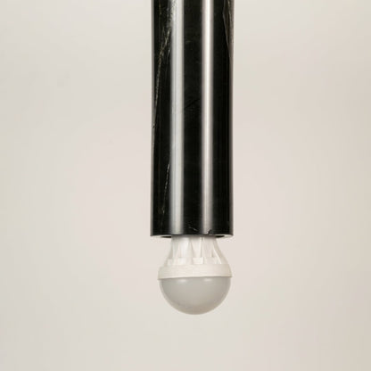 Black marble and metal long cylinder pendant light with clear bulb tip shown in close up view with light off for sleek modern décor.