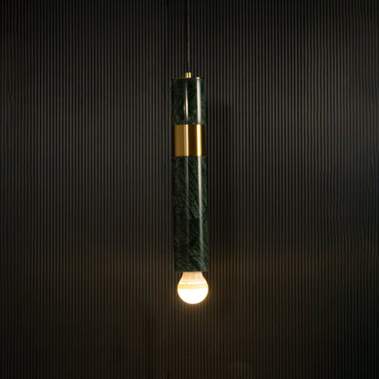 Green marble and metal cylinder pendant light with exposed bulb hanging against dark textured wall with light on for luxury modern décor.