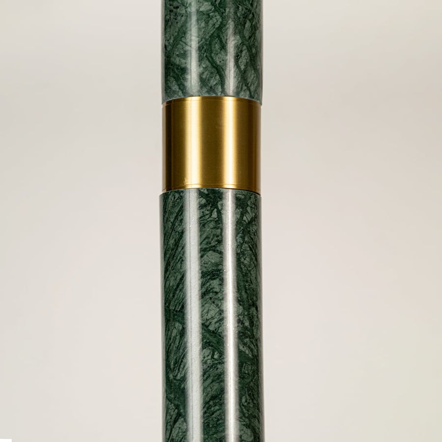 Green marble and metal long cylinder pendant light with clear bottom shown in close up view with light off for luxury modern décor.