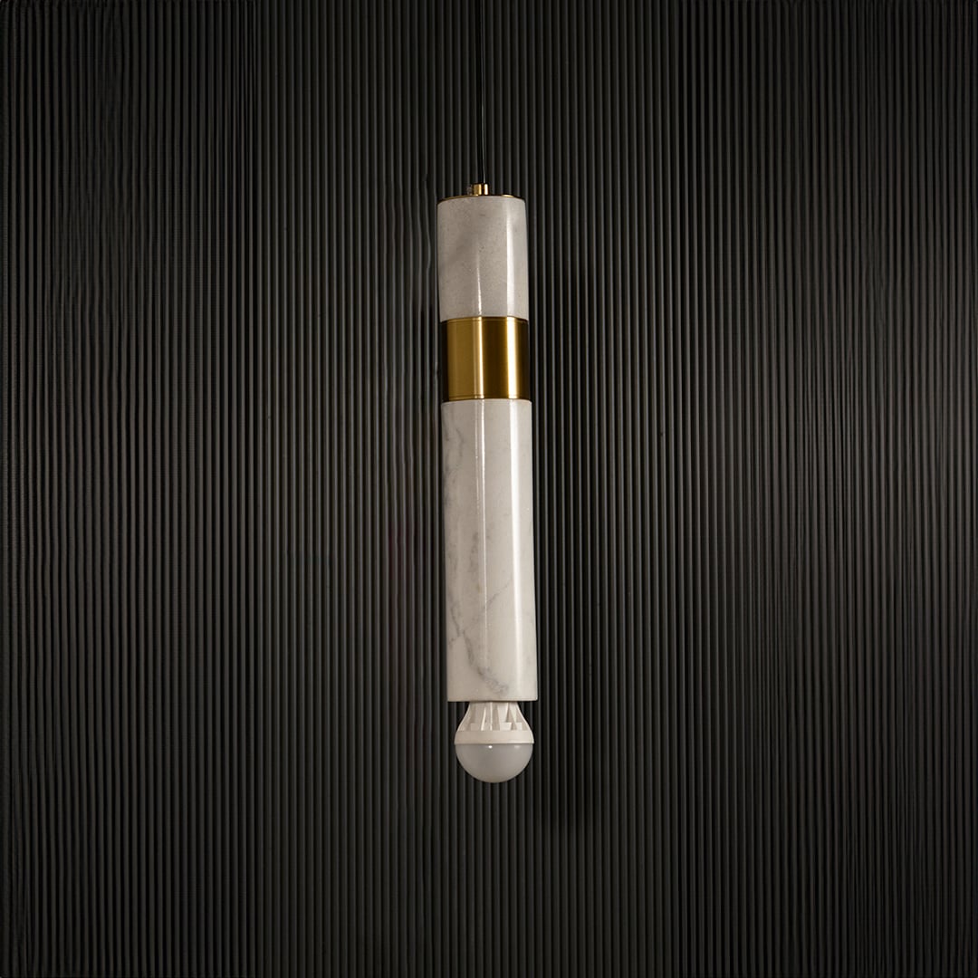 White marble and metal cylinder pendant light with exposed bulb hanging against dark textured wall with light off for modern elegant décor.