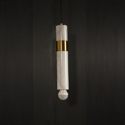 White marble and metal cylinder pendant light with exposed bulb hanging against dark textured wall with light off for modern elegant décor.