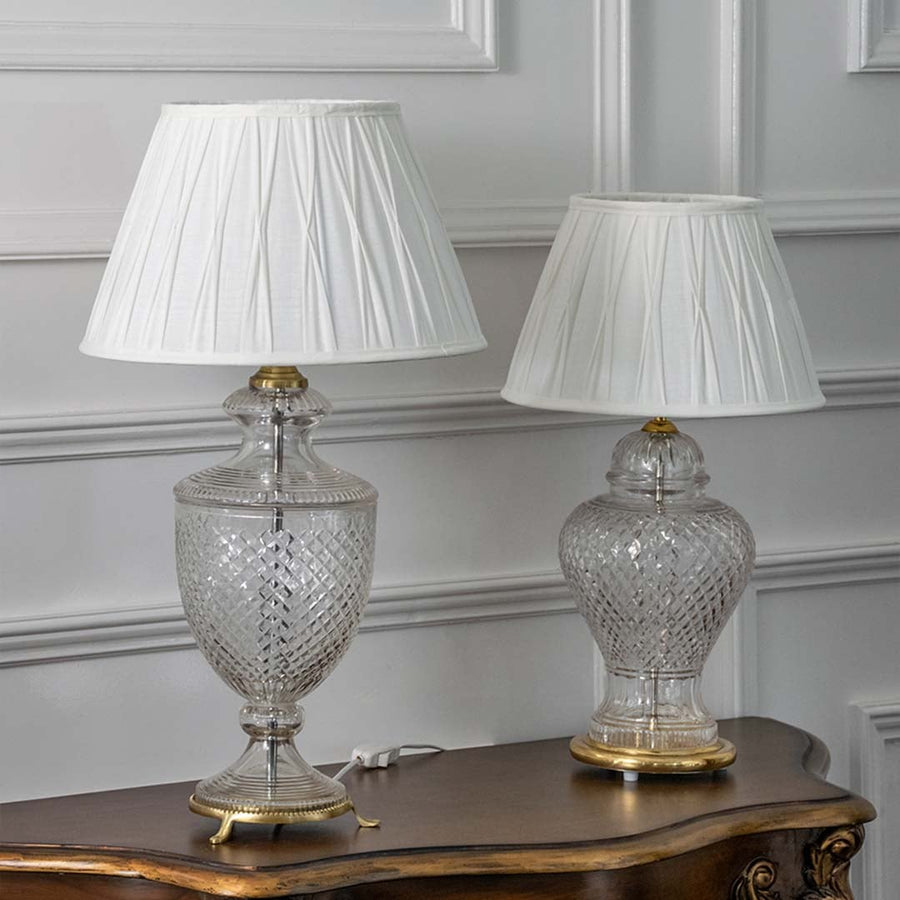 Pair of crystal glass table lamps with white pleated shades and gold accents for timeless luxury interior styling.