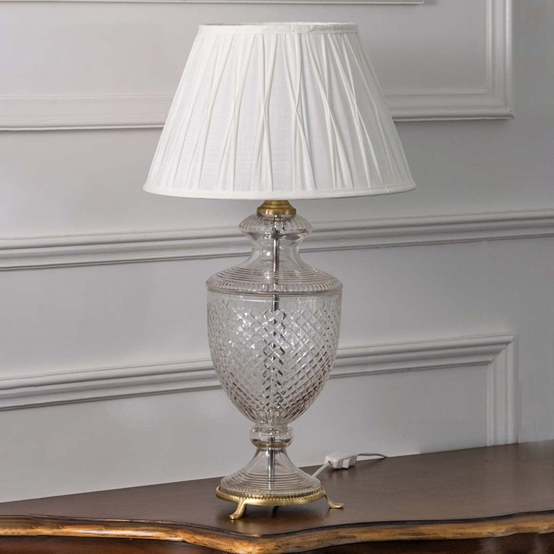 Crystal glass table lamp with white pleated shade and polished metal accents for classic luxury home decor.