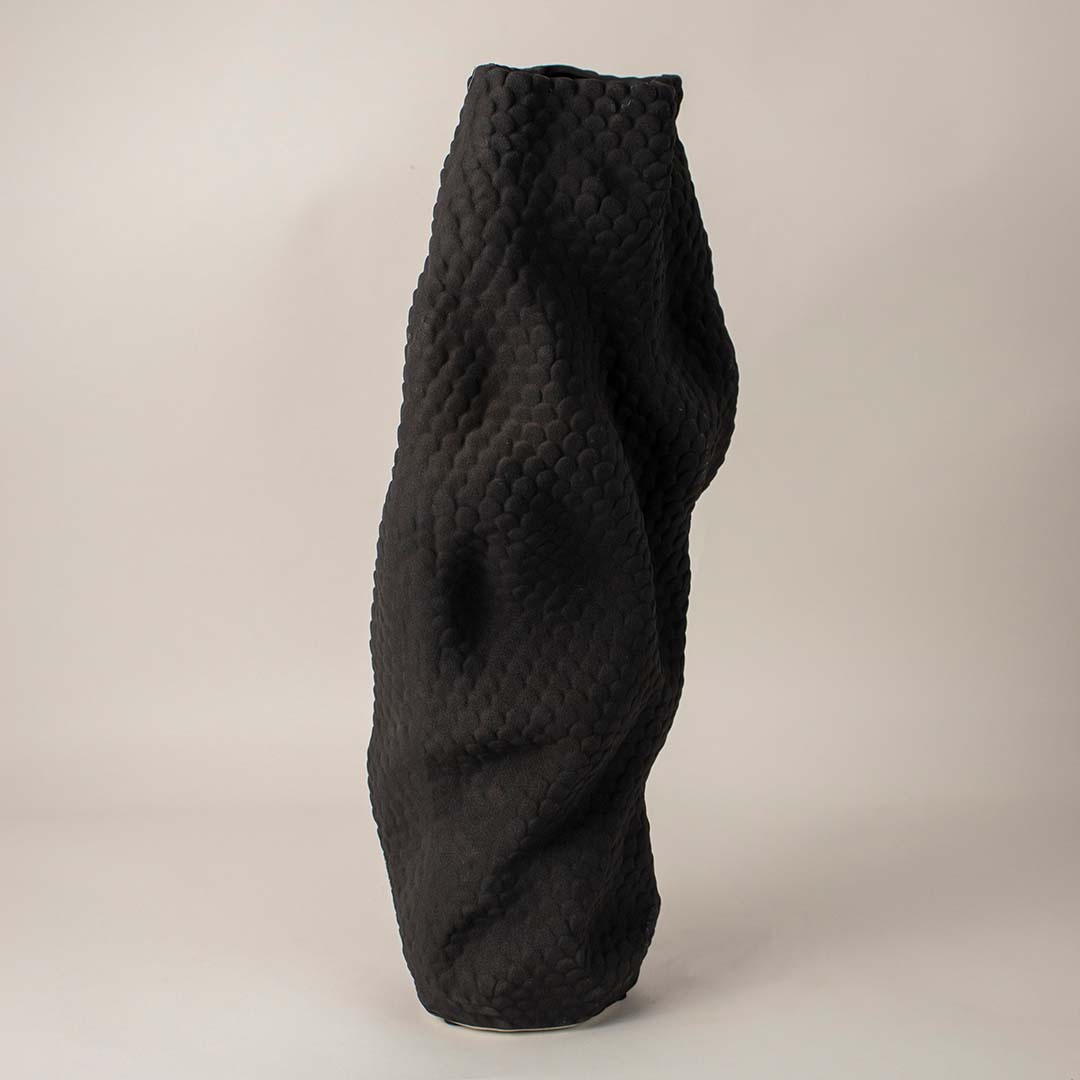 Sculptural black ceramic vase with detailed scale-like texture and organic design on clean white background for display.