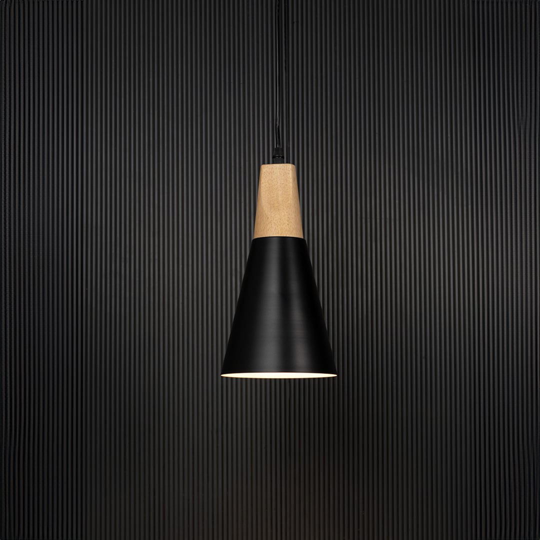 Black metal pendant light with wooden top and conical shade glowing on black background for modern home interiors.